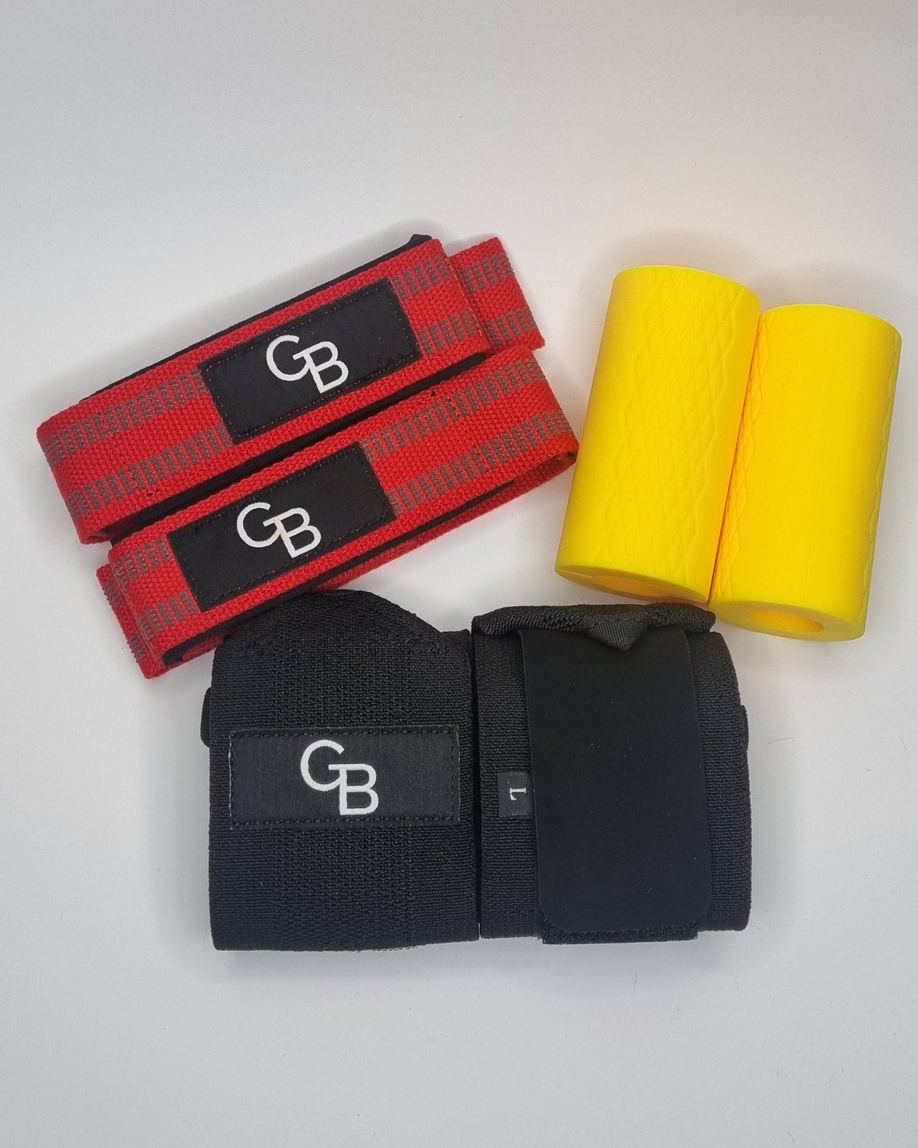 Two pairs of boxing gloves, one red and one black, with a yellow training aid on a white surface.