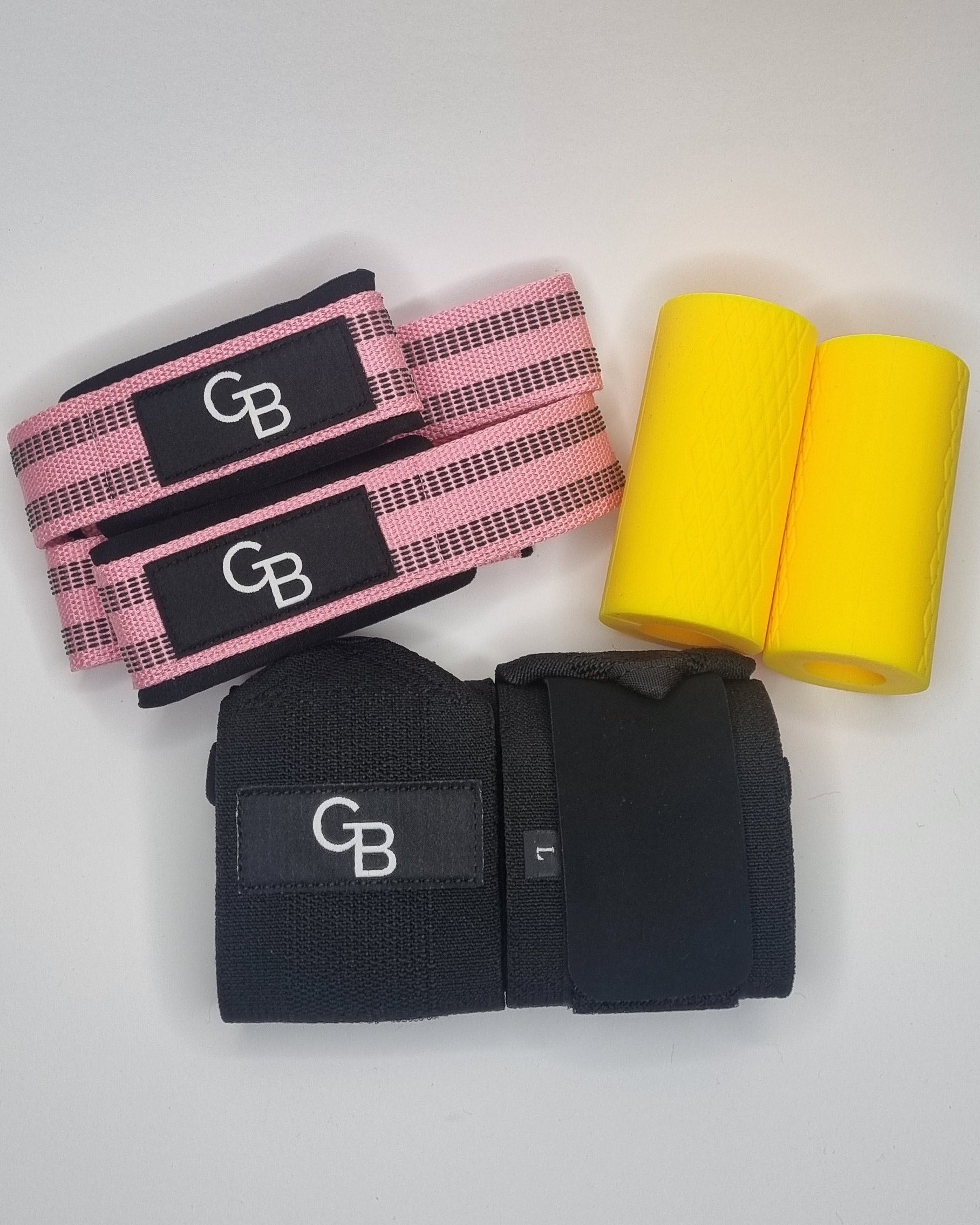 Yellow foam roller, black and pink resistance bands on a white surface