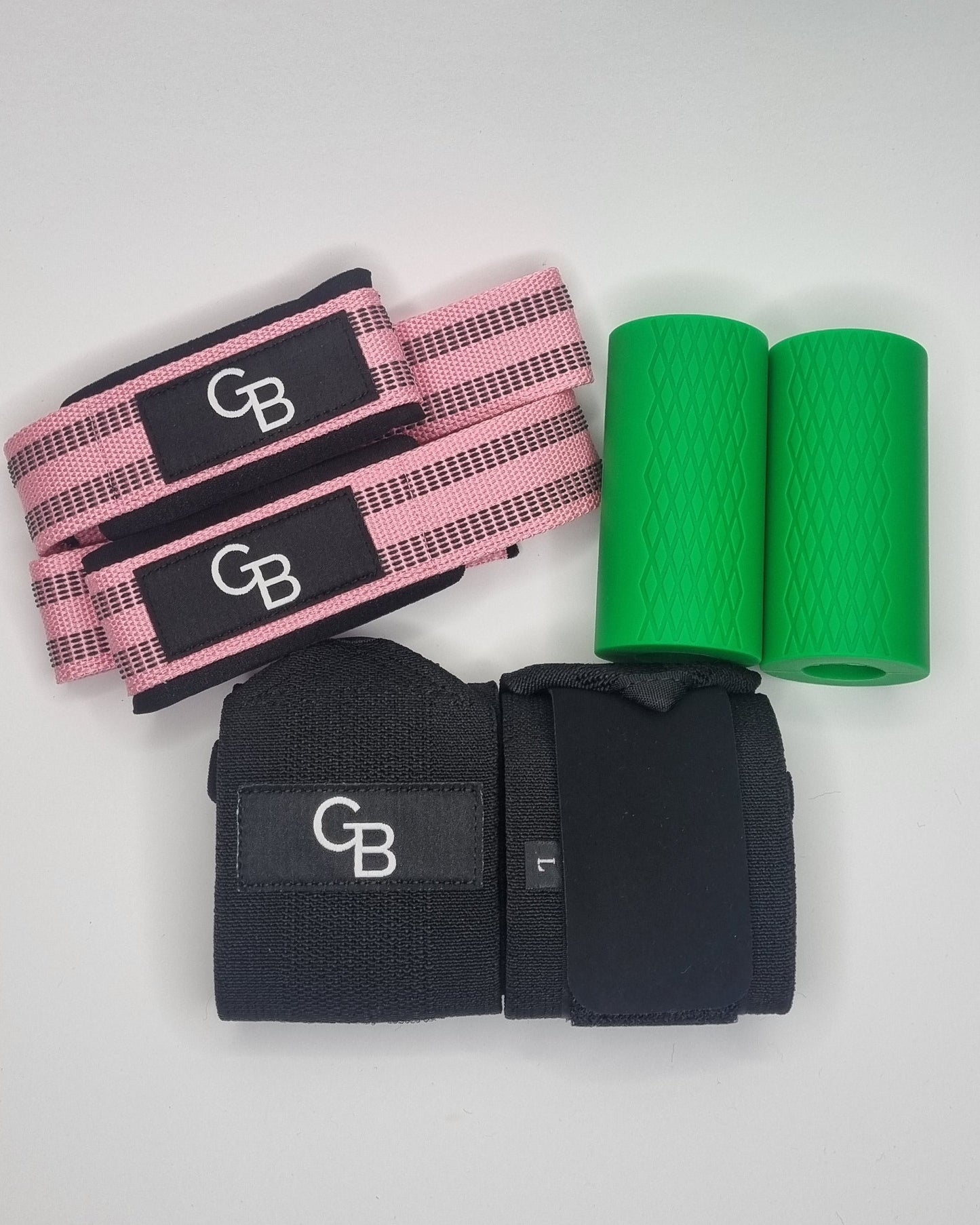 Green resistance band, black and pink GB straps on a white surface